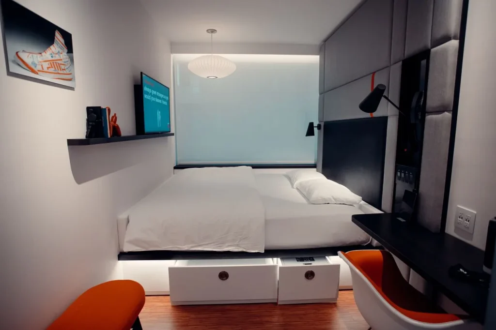 Cama clara com gavetas embutidas na base em um quarto contemporâneo.